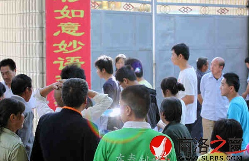 家們送考生進(jìn)入考場(chǎng)時(shí)，一縷光環(huán)閃現(xiàn)鏡頭中，這也許就是人們的理想與期待.jpg